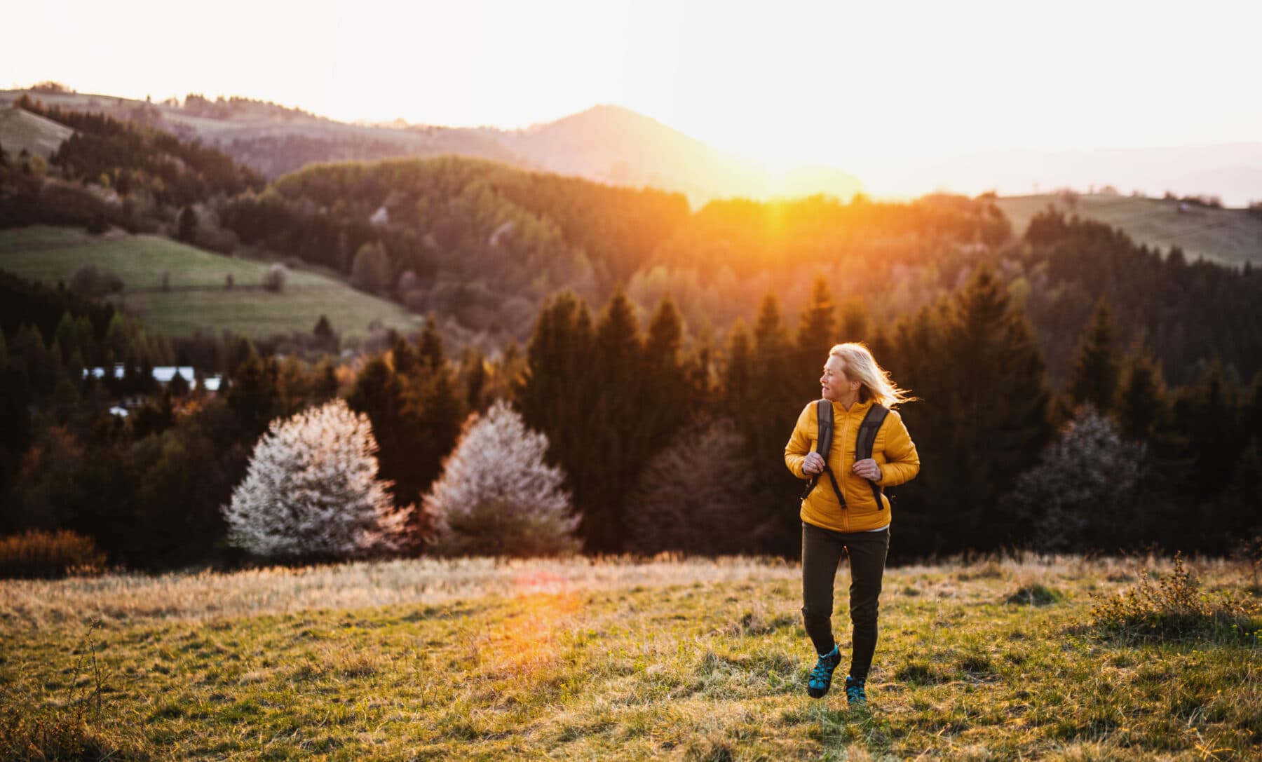 Lady in yellow jacket walking in the fields
